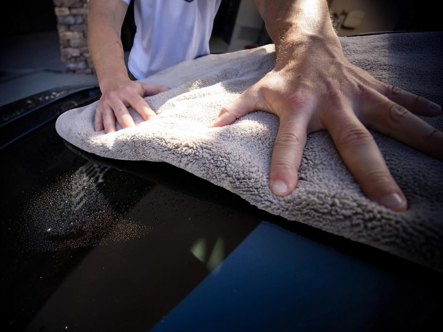 T-Top Vibes gray plush microfiber car drying towel being used to gently dry a vehicle hood