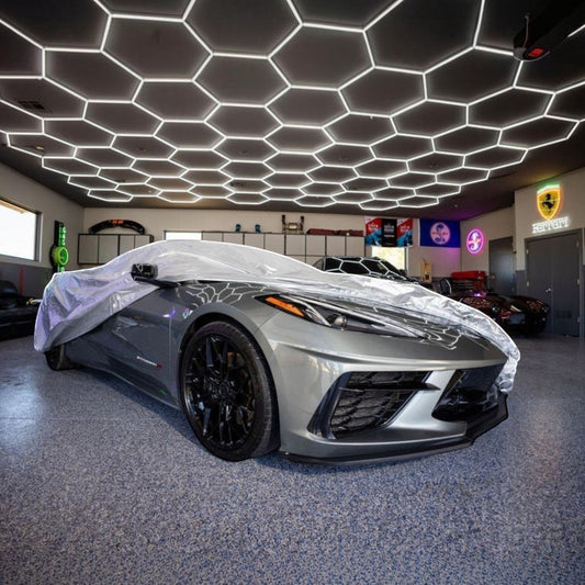 Corvette protected by a fitted car cover in a clean residential garage