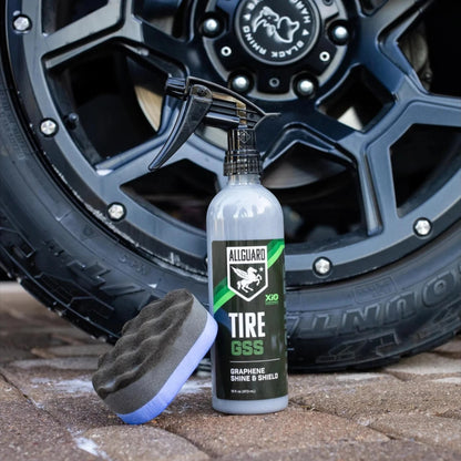 T-Top Vibes AllGuard Tire GSS graphene tire dressing spray bottle and applicator pad in front of a black car wheel