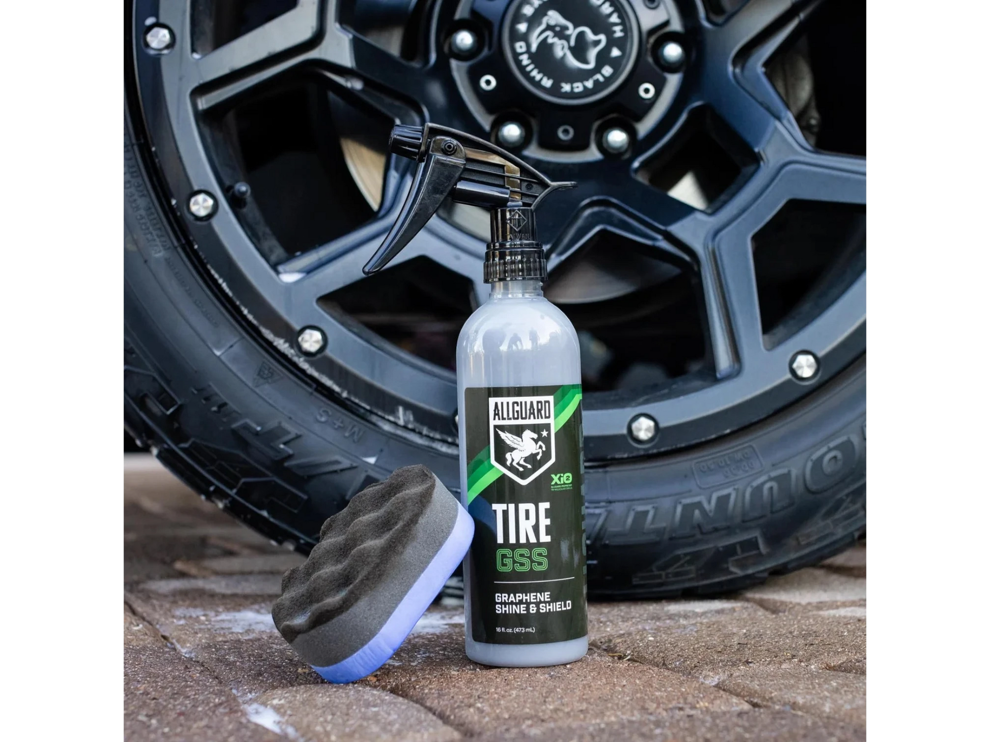 T-Top Vibes AllGuard Tire GSS graphene tire dressing spray bottle and applicator pad in front of a black car wheel