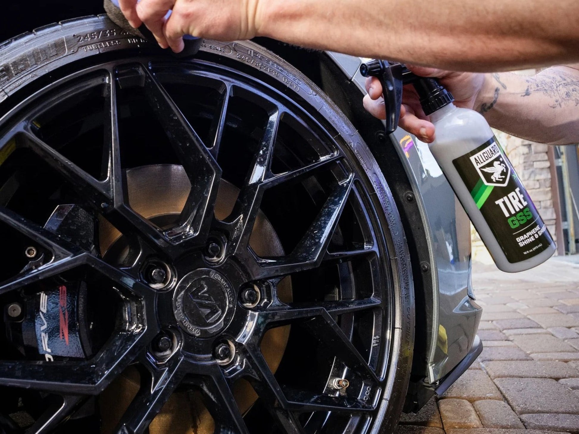 T-Top Vibes AllGuard Tire GSS graphene tire dressing being applied to a clean black car tire with an applicator pad.
