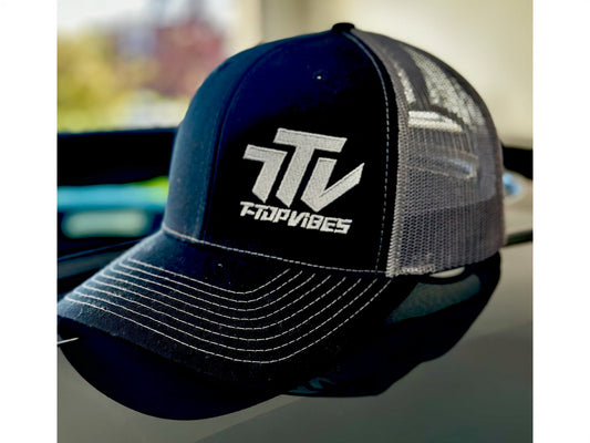 T-Top Vibes black and gray trucker hat with embroidered logo, featuring a curved visor and mesh back panel.