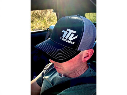 T-Top Vibes black and gray trucker hat with embroidered logo worn by a man inside a car