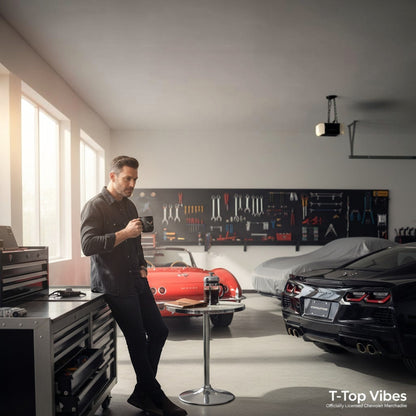 T-Top Vibes matte black ceramic C7 Corvette mug held by a man in a garage with classic and modern sports cars.