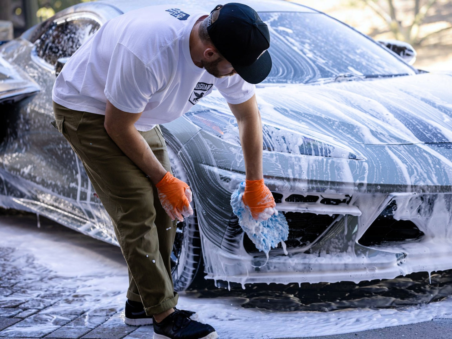 T-Top Vibes AllGuard VLUX ceramic car wash kit in use with a blue microfiber mitt cleaning a soapy sports car