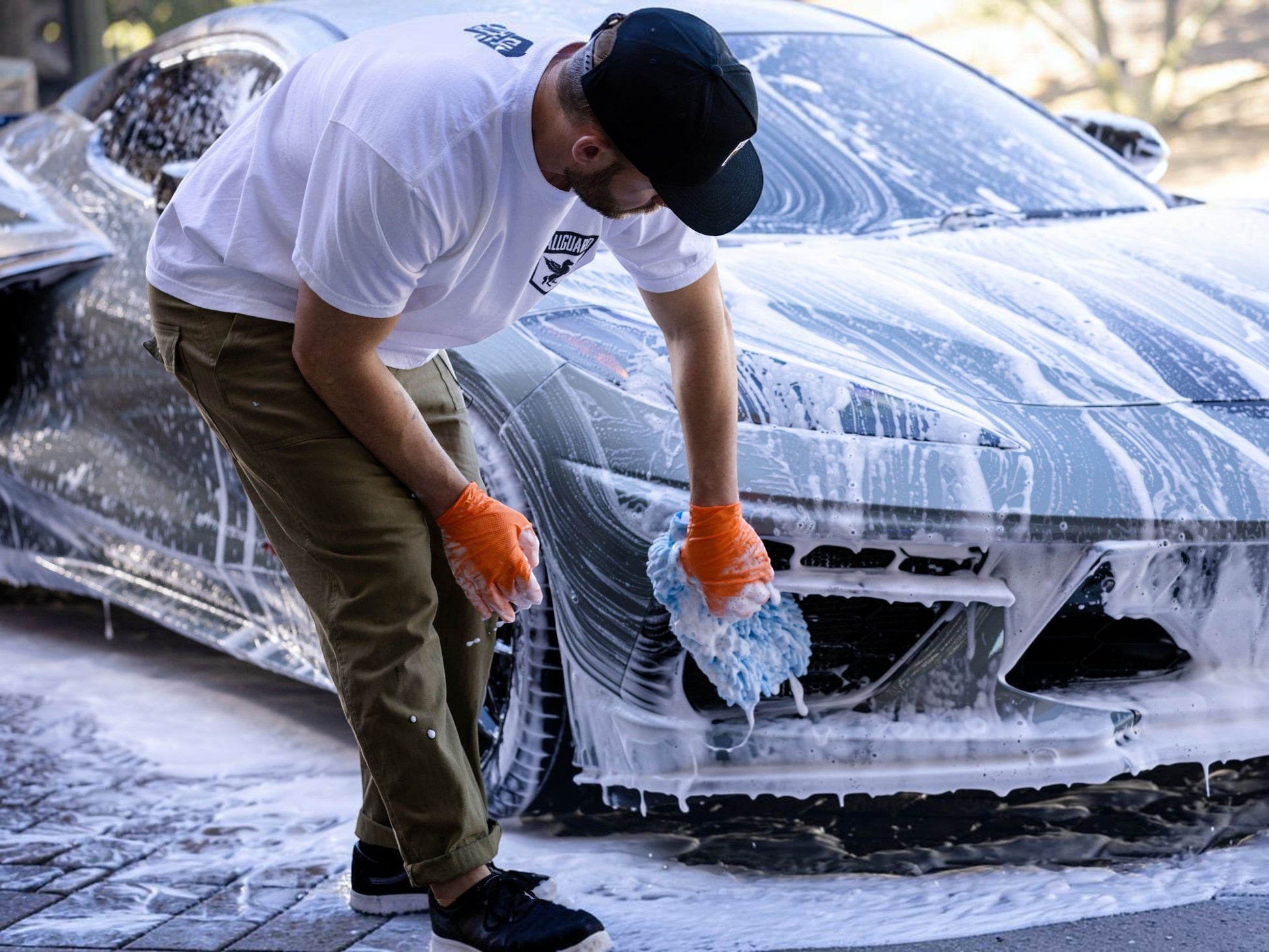 T-Top Vibes AllGuard VLUX ceramic car wash kit in use with a blue microfiber mitt cleaning a soapy sports car