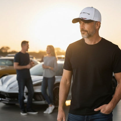 T-Top Vibes Corvette baseball cap with white crown, carbon-look bill, and embroidered C8 flags at a car show.