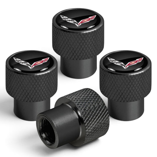 T-Top Vibes black anodized aluminum Corvette C7 valve stem caps with diamond-cut grip and crossed-flags emblem.
